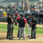 AND HERE ARE THE MANAGERS OR THEIR REPRESENTATIVES MEETING WITH THE UMPIRES AT FIRST BASE TO GO OVER THE GROUND RULES. THEY ARE ALSO ASKING WHO'S BUYING DINNER?